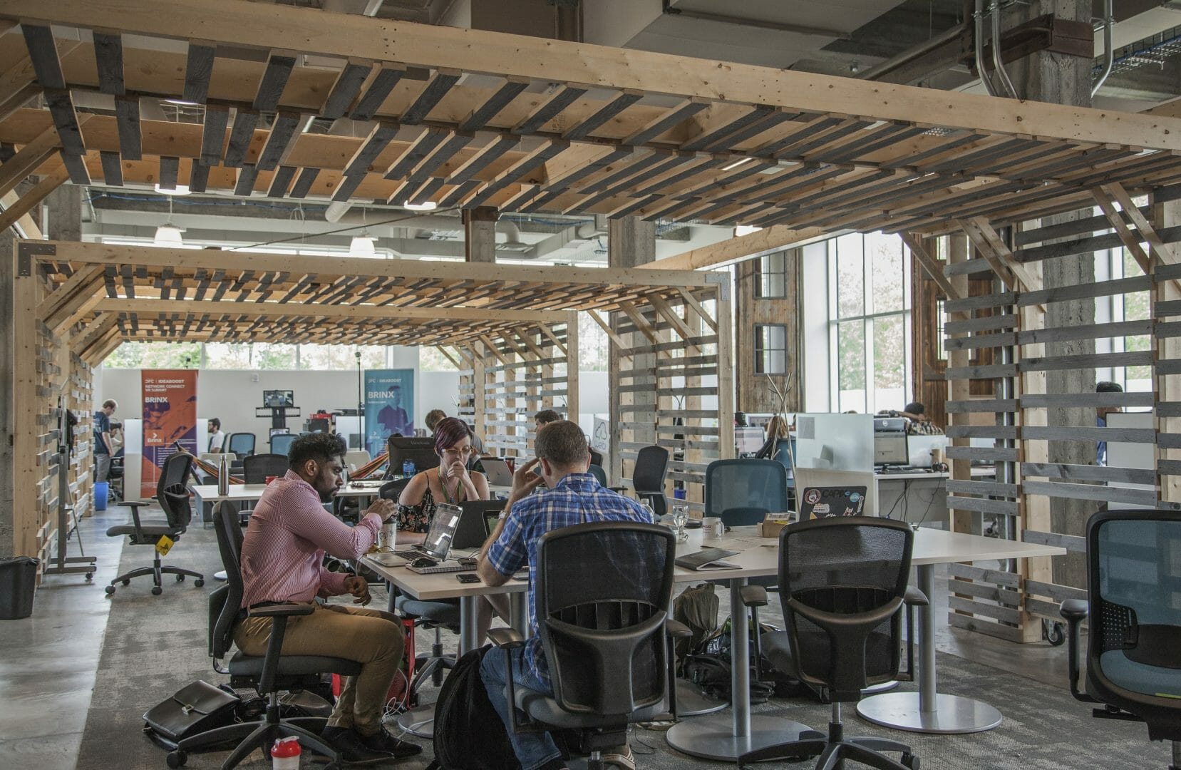 People sitting at Invest Ottawa's work area at the Bayview Yards building.